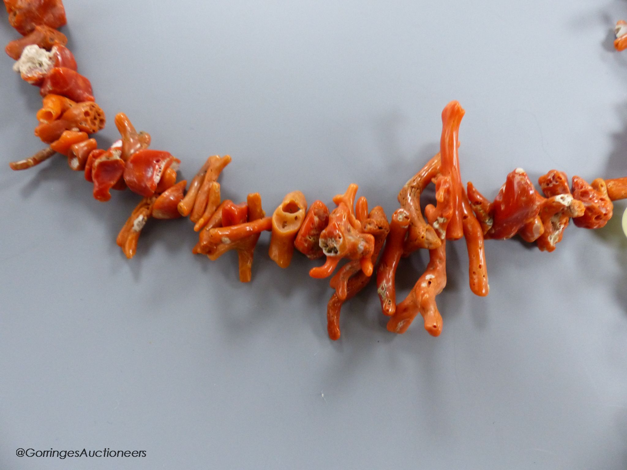 A jagged coral bead necklace, with jade pendant, carved as a fish, necklace approx. 88cm, fish length 66mm, gross weight 114 grams.